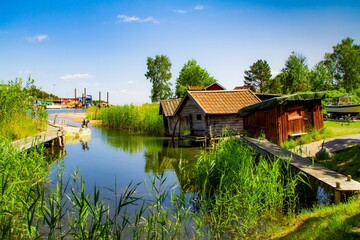 Obraz premium Countryside landscape with small wooden houses on the bank of the river