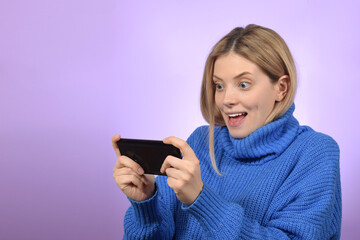 Fototapeta premium cute pretty blonde woman playing mobile game