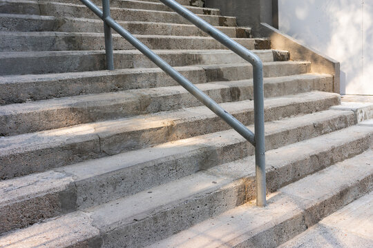 Concrete staircase with metal handrail for safety. Public footpath  for walking up or down.