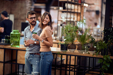 Young couple in cafe having a great time. Cheerful people, standing at the bar.