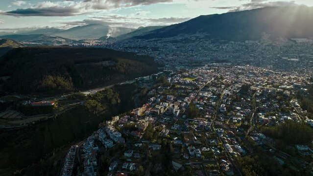 Bird's eye view of houses in green hills on a sunny day in Quito, Ecuador