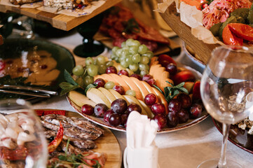 A set of Italian snacks for a buffet. A variety of cheeses, cold cuts bruschetta, pickled cucumbers, tomatoes on a wooden background