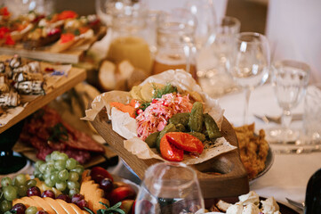 A set of Italian snacks for a buffet. A variety of cheeses, cold cuts bruschetta, pickled cucumbers, tomatoes on a wooden background
