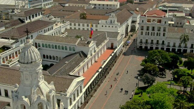 Footage of the city of Quito in Ecuador with the country's flag waving on the roof and a crowdy city