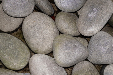 Large river rocks on wet pavement texture
