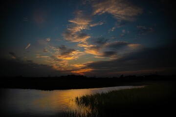 Fototapeta na wymiar Beautiful sunset on Shem creek with a cloudy blue sky in the background, South Carolina