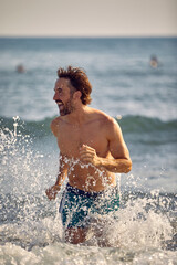 crazy man running in the water on the beach