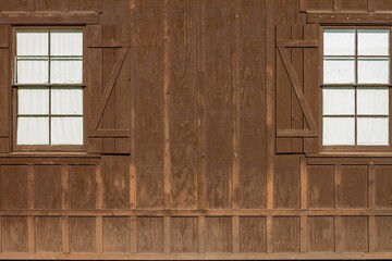 Exterior design of a wooden barn with two windows on a sunny day