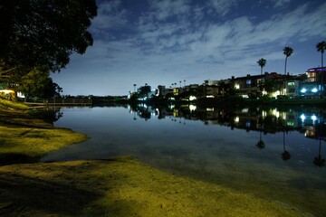 Fototapeta na wymiar Scenic shot of buildings on the coast of a lake during nighttime