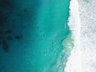 View from above, stunning aerial view of a person surfing on a turquoise ocean. Fuerteventura, Canary Islands, Spain. - obrazy, fototapety, plakaty