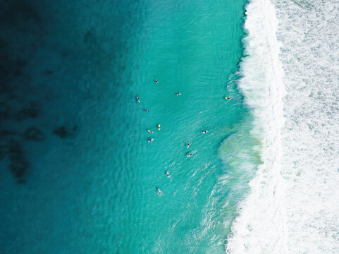 View from above, stunning aerial view of a person surfing on a turquoise ocean. Fuerteventura, Canary Islands, Spain.