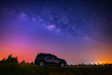 Fototapeta na wymiar Black camp car at night with many stars before sunrise. Space background with noise and grain. Night landscape with car and colorful bright milky way.Beautiful scene with universe. 