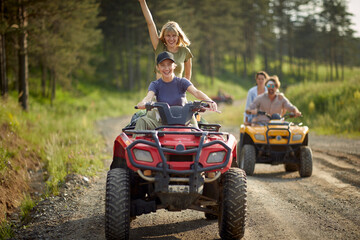 Group of sporty friends driving quads together