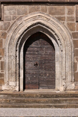 Pointed gothic arch with ancient wooden door at St. Katharinen monastery church in the old town of Halberstadt in Sachsen-Anhalt region, Germany