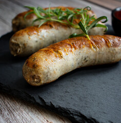 
Fried homemade sausages on a wooden background. With sauces. lunch