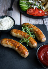 
Fried homemade sausages on a wooden background. With sauces. lunch