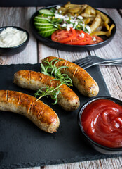 
Fried homemade sausages on a wooden background. With sauces. lunch