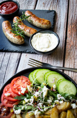 
Fried homemade sausages on a wooden background. With sauces. lunch