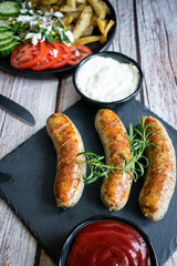 
Fried homemade sausages on a wooden background. With sauces. lunch