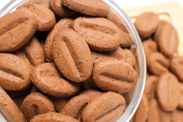 Concept of tasty snack for hot drink - cookies in the shape of coffee seeds