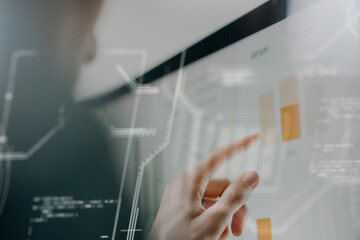 Futuristic concept female hand pointing to growth charts on a computer monitor studying and analyzing and processing the information with the help of AI