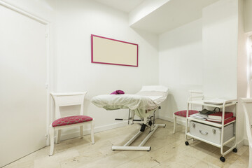 Fototapeta na wymiar Cabin to apply treatments in a dermoesthetic clinic with stretcher and seats