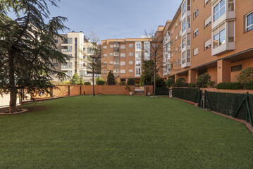 Garden with artificial grass inside a block patio of a community of urban residential buildings