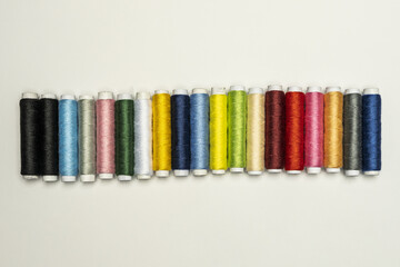 a horizontal strip of spools of colored sewing threads