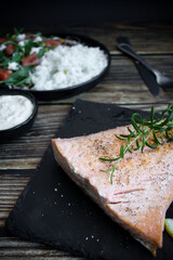 Cooked salmon with rice and salad. On a wooden background. dinner