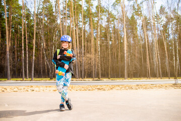 happy child schoolboy hugging his bright plastic city cruiser, skateboard. in the park.