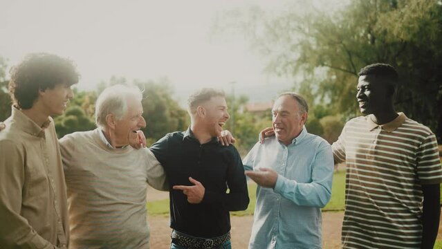 Happy multigenerational group of men with different ethnicities having fun in a public park - People diversity concept