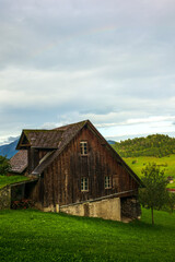 Fototapeta na wymiar Green hills and farm buildings near the Buergenstock in the countryside of Lucerne in Switzerland