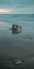 Naklejka premium Long exposure seascape of rocks on a beach