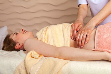 Fototapeta na wymiar Belly massage. masseuse or massage therapist massaging girl's Abdomen.