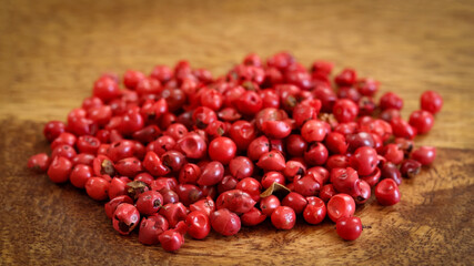 baies roses, en gros plan, sur une table en bois	