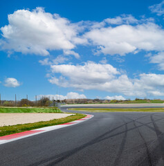 Motor sport asphalt race track and curbs with skid marks, low angle view