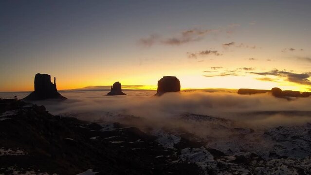 Time lapse video of a panoramic view of Monument Valley, USA, at sunrise in winter with snow