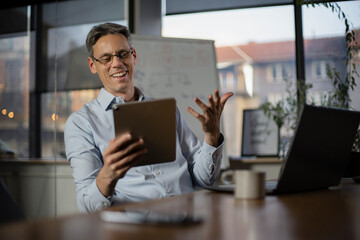 Portrait of businessman in office. Man using digital tablet. Businessman having video call.