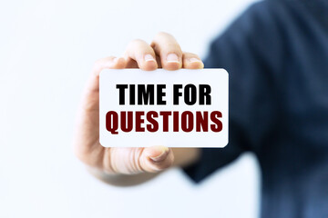 Time for questions on blank business card being held by a woman's hand with blurred background. Business concept about time for questions.
