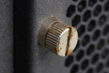 A rusty metal screw that secures the computer server panel.