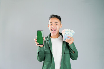a young asian man is holding a smartphone and some money
