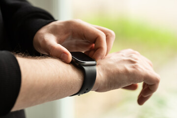 Close up shot of a businessman's hand that uses a smart watch, business and technology concept, copy space.