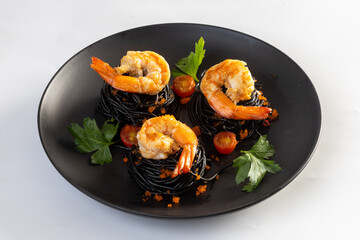 Squid ink spaghetti with prawns on white background