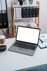 Stylish workspace with laptop, notebook, blank screen laptop on white table of bookkeeping.