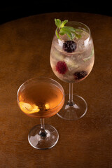 Two glasses of cocktails on wooden table with close-up top view