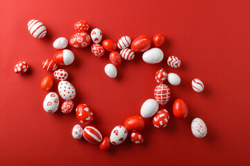 Easter backgrounds with a heart frame of Easter red and white eggs on a bright red background. A place to copy. Flat position, top view.