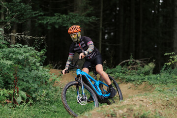 Fototapeta premium Cyclist Riding the Bike in the Beautiful Mountains Down the Rock on Background. Extreme Sport and Enduro Biking Concept