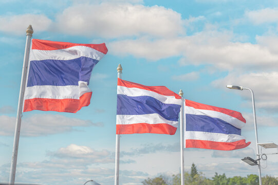 thailand flag. Image of waving three Thai flags of Thailand with blue sky background.
