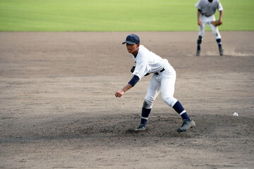 投球直後の左腕投手（高校野球）