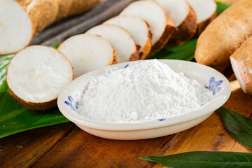 pile of cassava, and cassava flour on a background of rustic wood (Manihot esculenta)